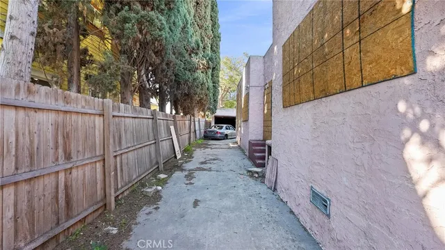 a view of a pathway of a backyard with wooden fence
