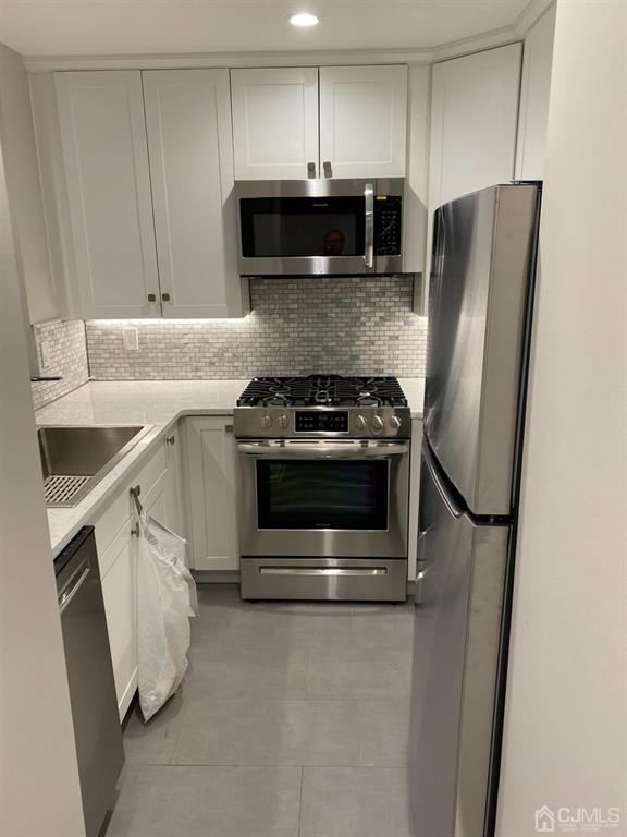 218 Edpas Road New Brunswick, NJ 08901 - Photo 4 of 17 a kitchen with stainless steel appliances granite countertop a stove a refrigerator and a microwave