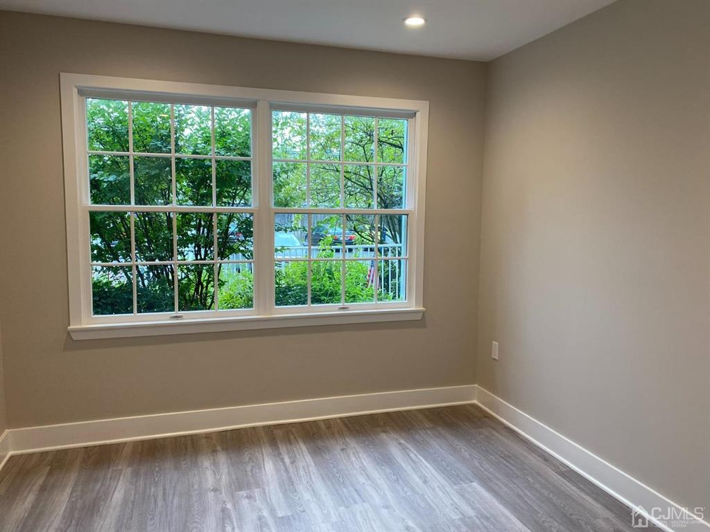 218 Edpas Road New Brunswick, NJ 08901 - Photo 7 of 17 a view of an empty room with wooden floor and a window