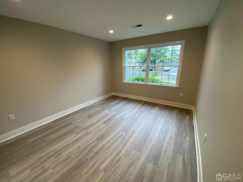 218 Edpas Road New Brunswick, NJ 08901 - Photo 9 of 17 an empty room with wooden floor and windows
