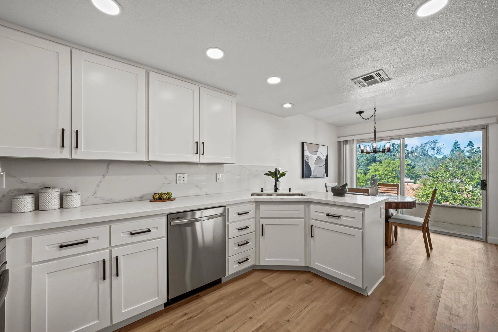 1274 Rue St Moritz San Marcos, CA 92078 - Photo 6 of 39 a kitchen with white cabinets and wooden floors
