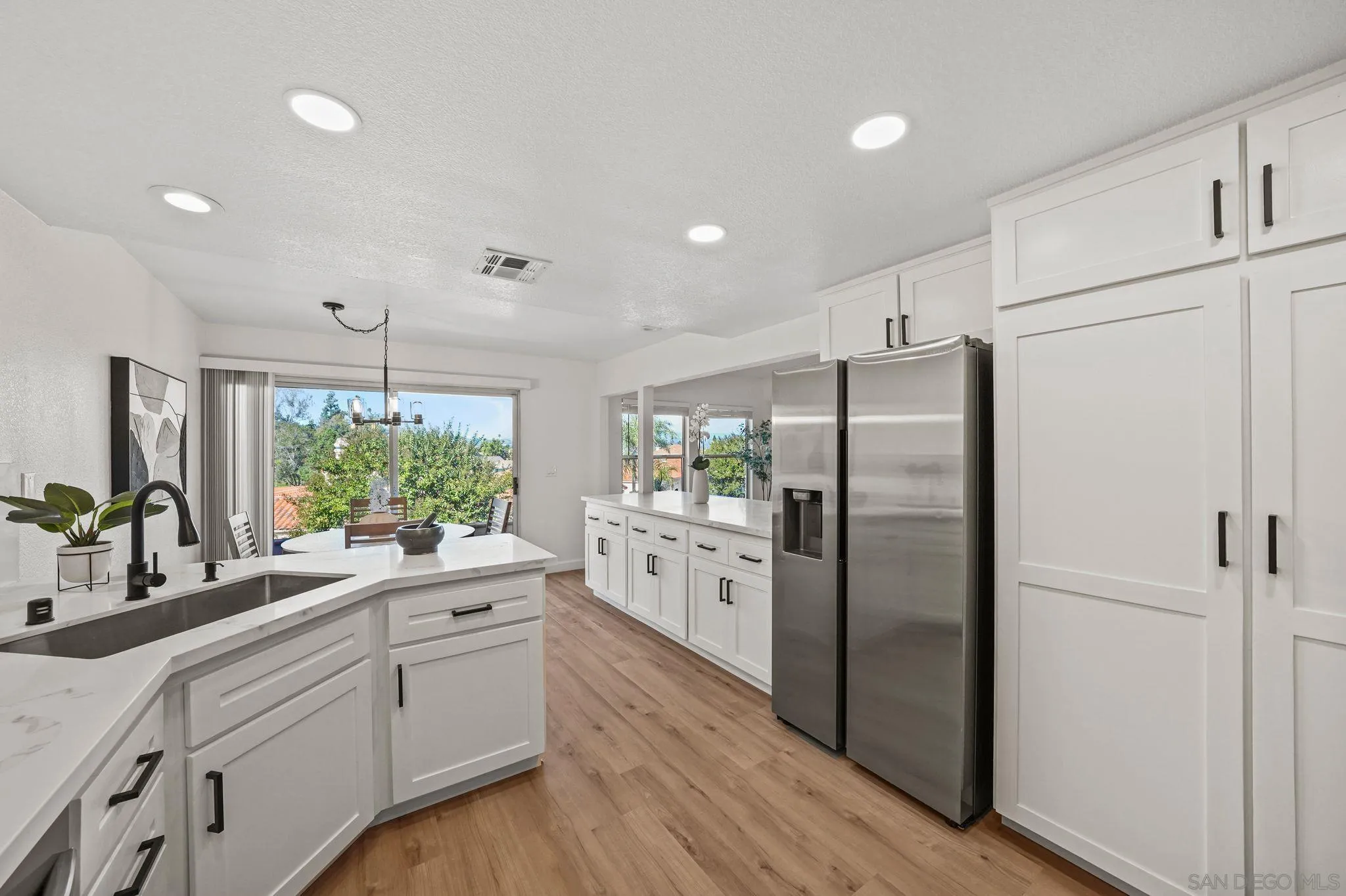 1274 Rue St Moritz San Marcos, CA 92078 - Photo 9 of 39 a kitchen with white cabinets and stainless steel appliances