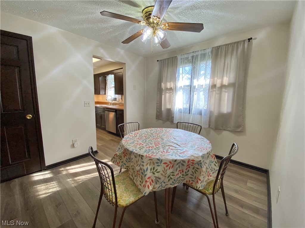 23551 Sandy Creek Road Minerva, OH 44657 - Photo 10 of 35 Dining space featuring a textured ceiling, ceiling fan, light wood-type flooring, and sink