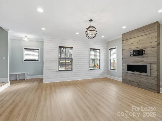 an empty room with windows and fireplace