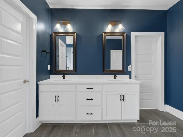 a bathroom with a double vanity sink and a mirror