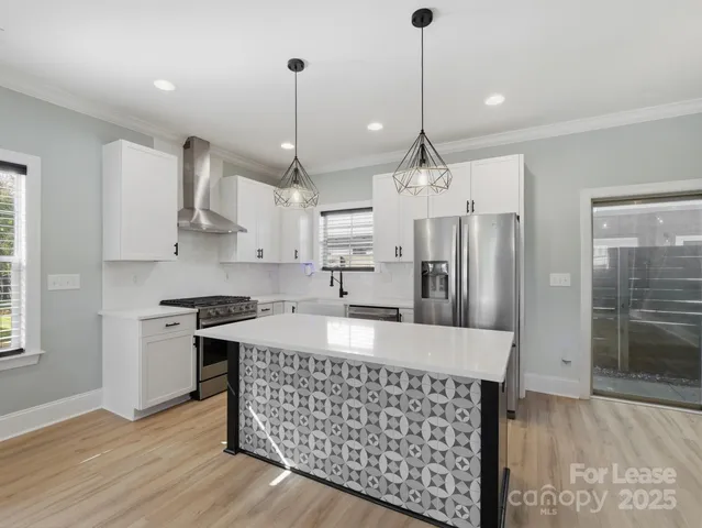 a kitchen with stainless steel appliances granite countertop a sink a stove a refrigerator a center island a stove and a window