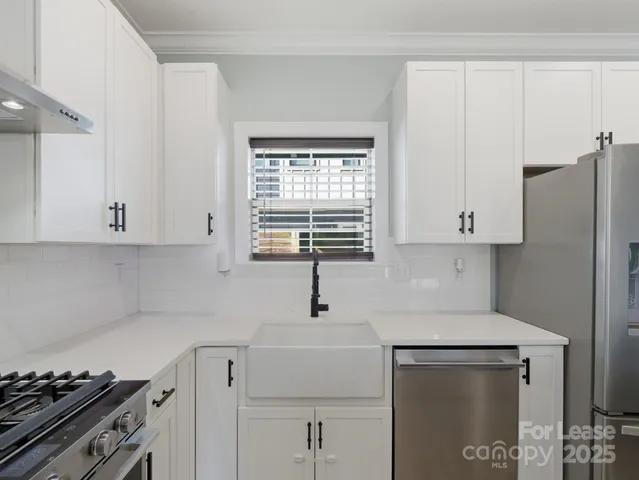 a kitchen with stainless steel appliances a sink stove and white cabinets