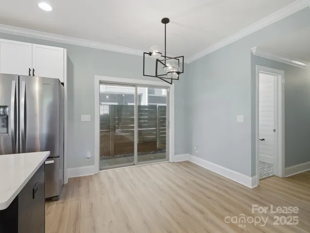 a view of empty room with wooden floor and window
