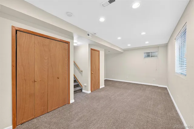 an empty room with closet and a window