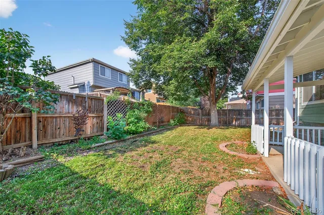 a view of a house with backyard and wooden fence