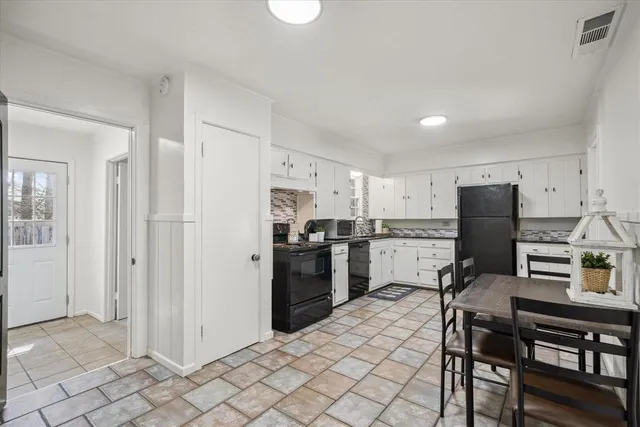a kitchen with a refrigerator and a stove top oven
