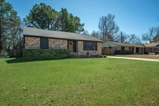 a view of a house with a yard and sitting area