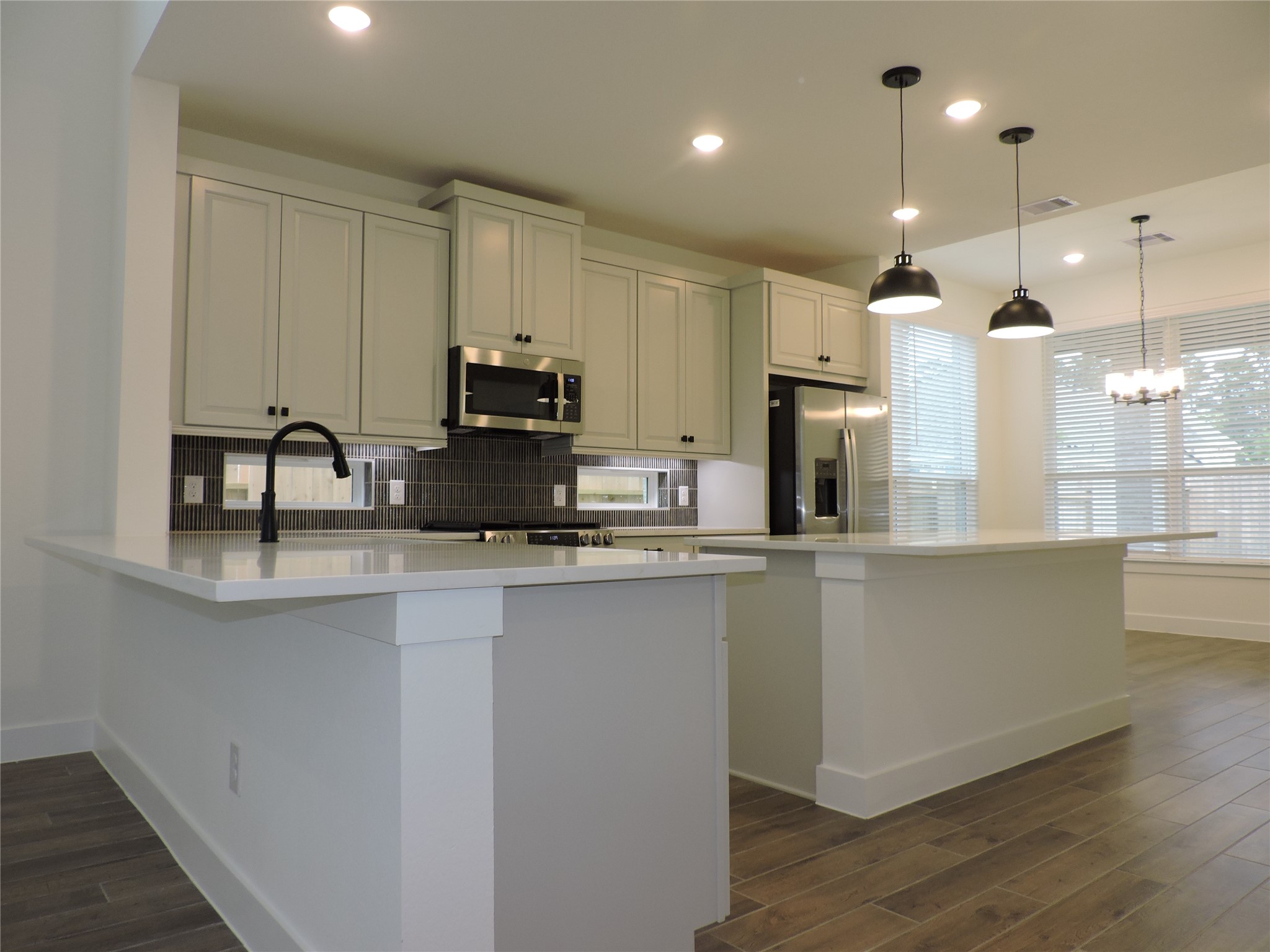12853 Meadow Wind Way Conroe, TX 77302 - Photo 10 of 34 Modern design throughout this home featuring Quartz counters, breakfast bar, large island, gas range, lots of cabinetry. Refrigerator is included.