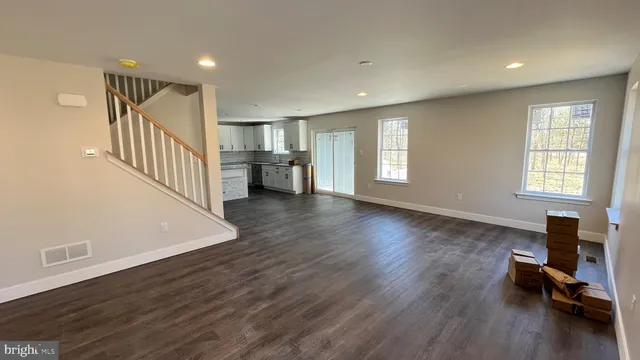a view of a kitchen with refrigerator microwave and wooden floor