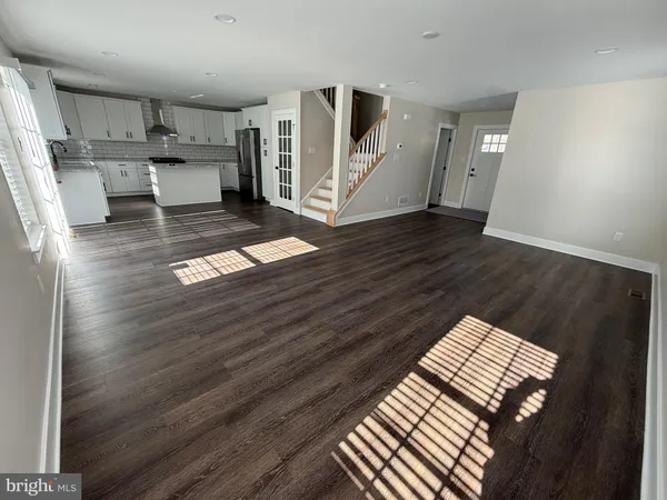 a kitchen with white cabinets appliances and wooden floor