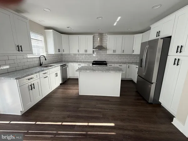 a view of an empty room with wooden floor and window