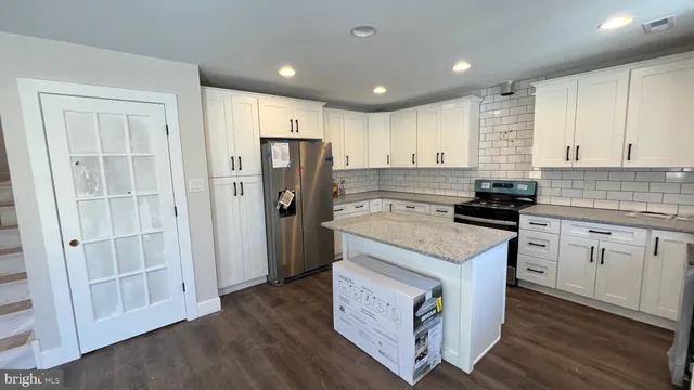a kitchen with a stove sink and cabinets