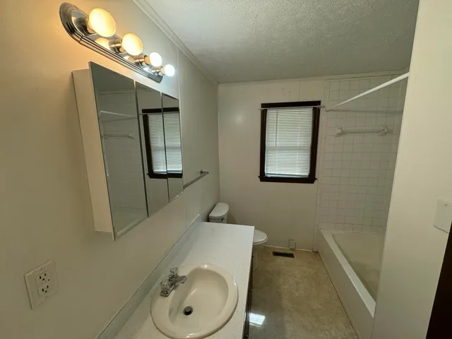 a bathroom with a toilet sink and mirror