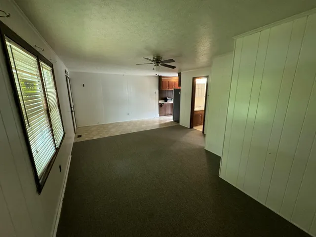 a view of empty room with wooden floor and window