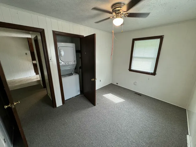 an empty room with windows and closet