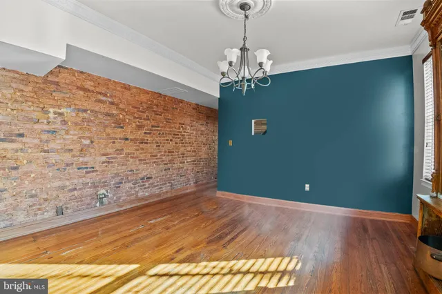 a view of a livingroom with a chandelier fan and windows