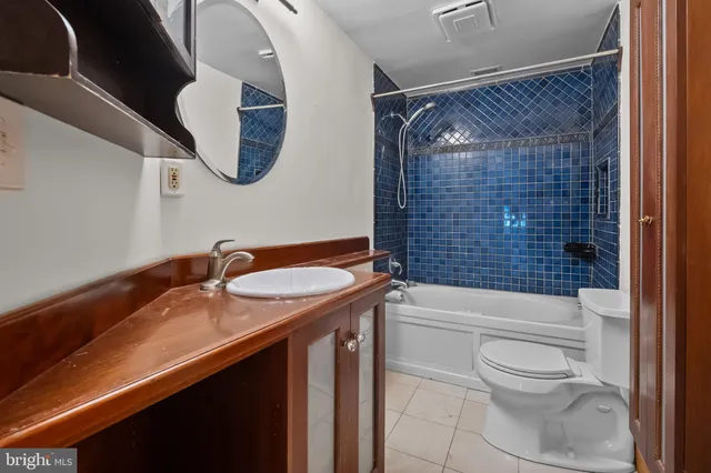 a bathroom with a granite countertop toilet sink and mirror
