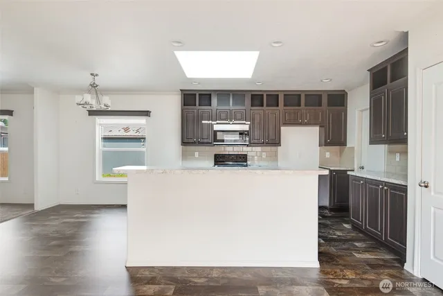 a kitchen with kitchen island wooden cabinets and refrigerator