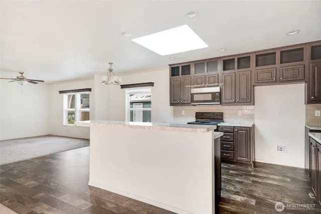 a kitchen with granite countertop a refrigerator stove top oven and sink