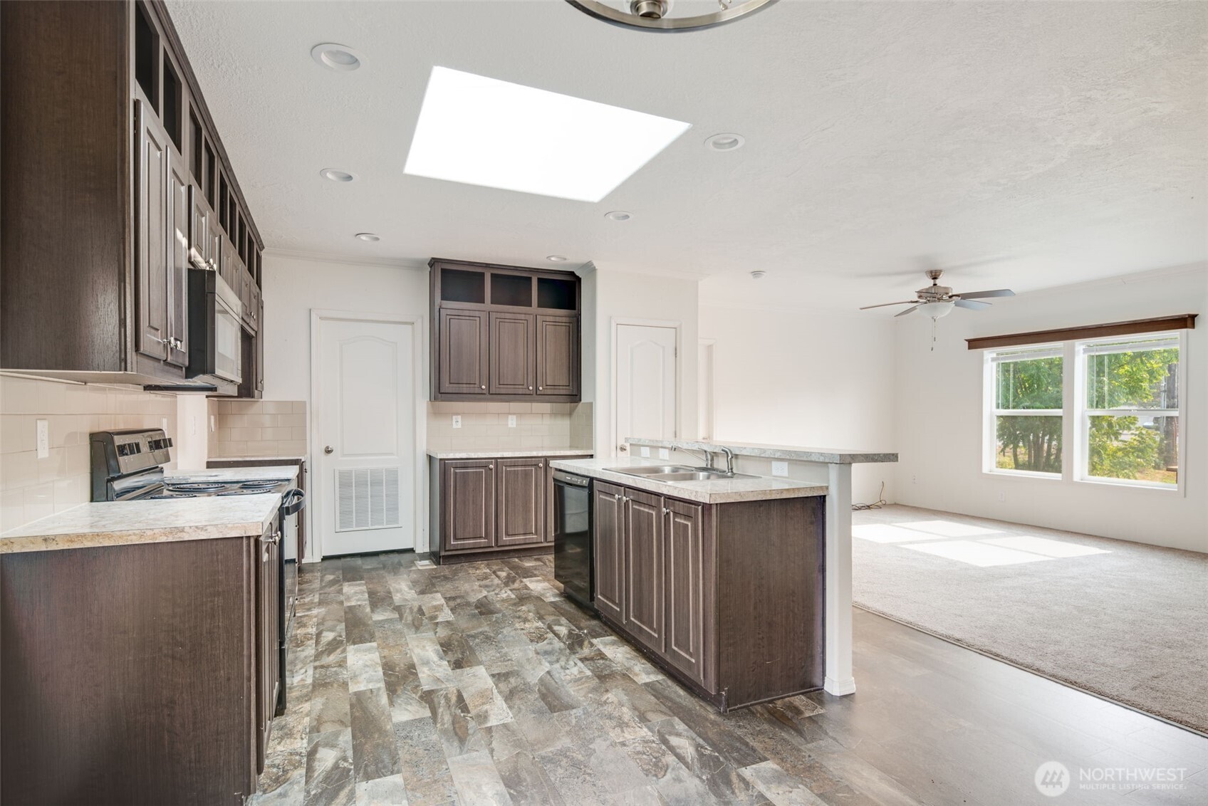 4322 Ocean Beach Highway Longview, WA 98632 - Photo 14 of 40 a large kitchen with kitchen island granite countertop a sink and a stove top oven