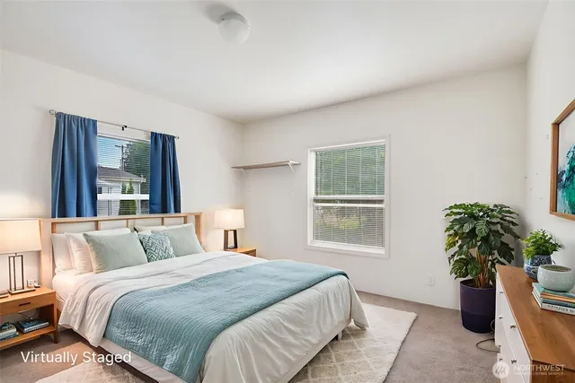 a bedroom with a large bed and a potted plant