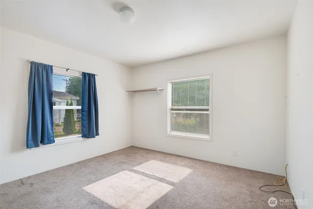 an empty room with windows and closet