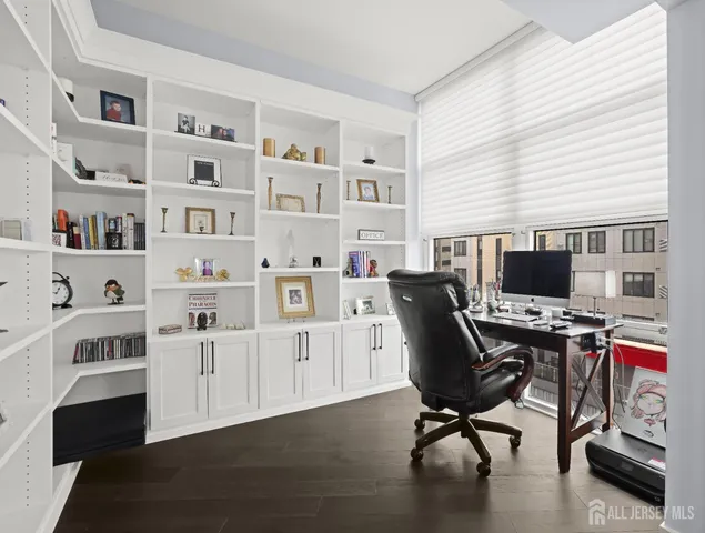 a view of a workspace with furniture and a window