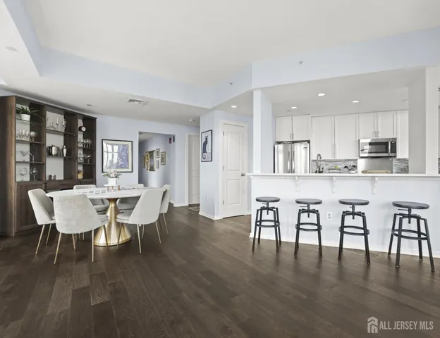 a view of a dining room with furniture wooden floor and a kitchen