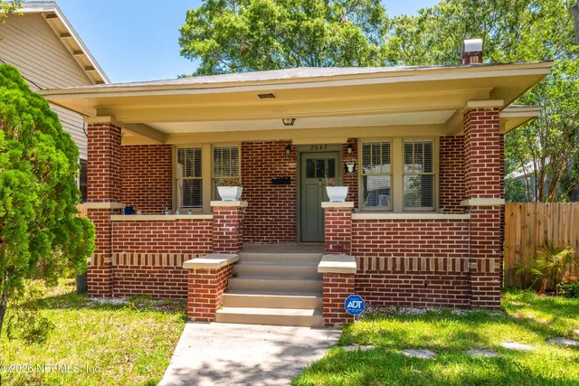 a view of entrance gate of a house with a garden