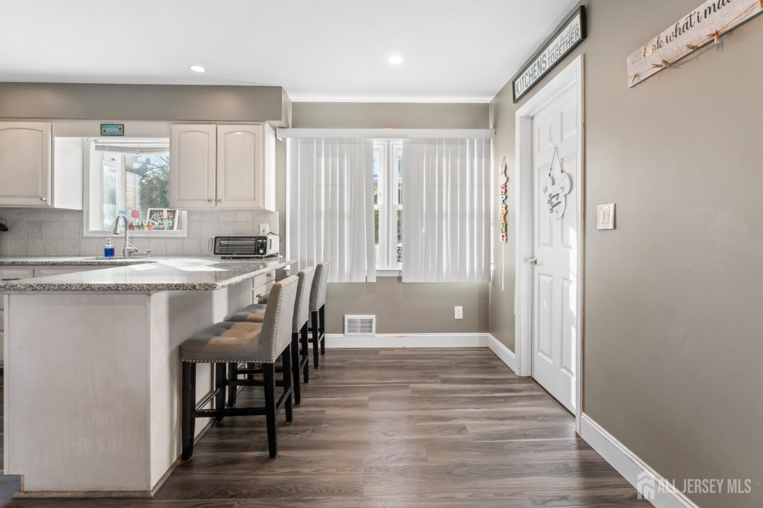 4 Whitman Road Morganville, NJ 07751 - Photo 11 of 45 a dining hall with stainless steel appliances granite countertop a stove a sink and a refrigerator with wooden floor