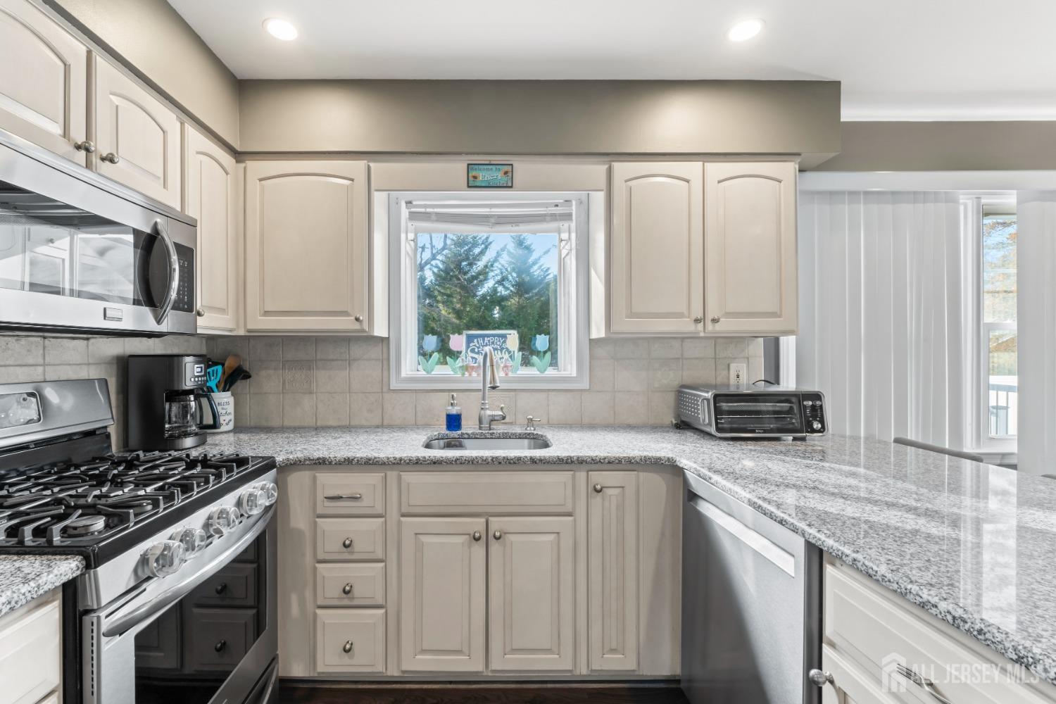 4 Whitman Road Morganville, NJ 07751 - Photo 13 of 45 a kitchen with stainless steel appliances granite countertop a sink stove and cabinets