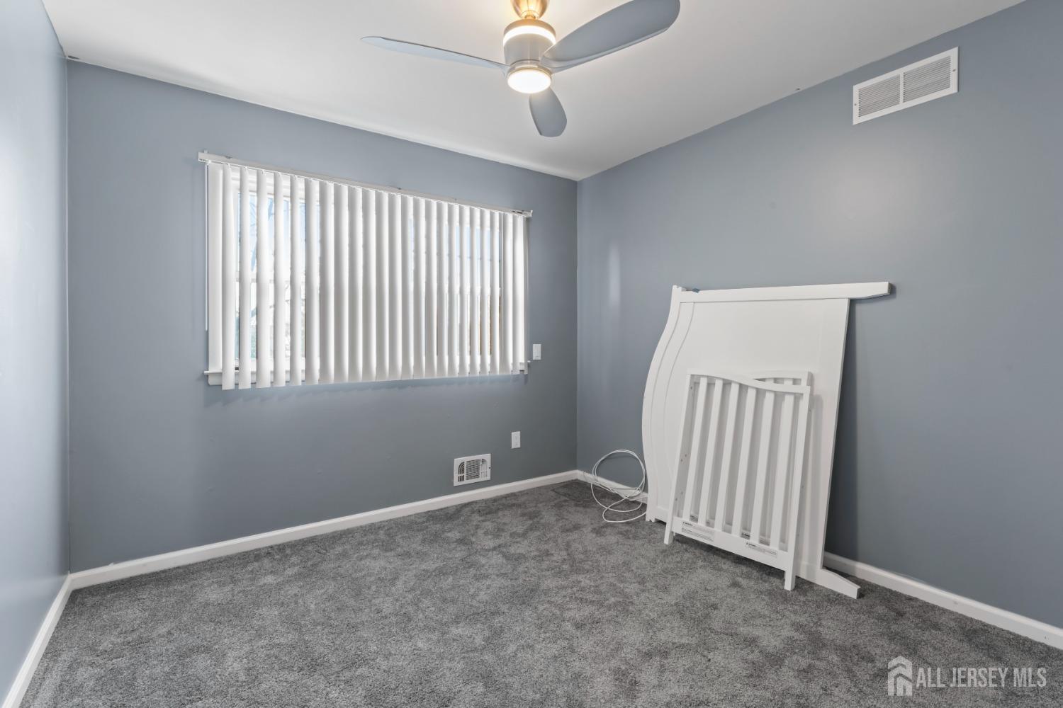 4 Whitman Road Morganville, NJ 07751 - Photo 23 of 45 an empty room with windows and ceiling fan