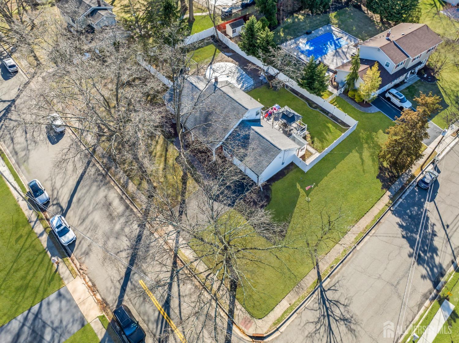 4 Whitman Road Morganville, NJ 07751 - Photo 38 of 45 an aerial view of a house with a garden and swimming pool