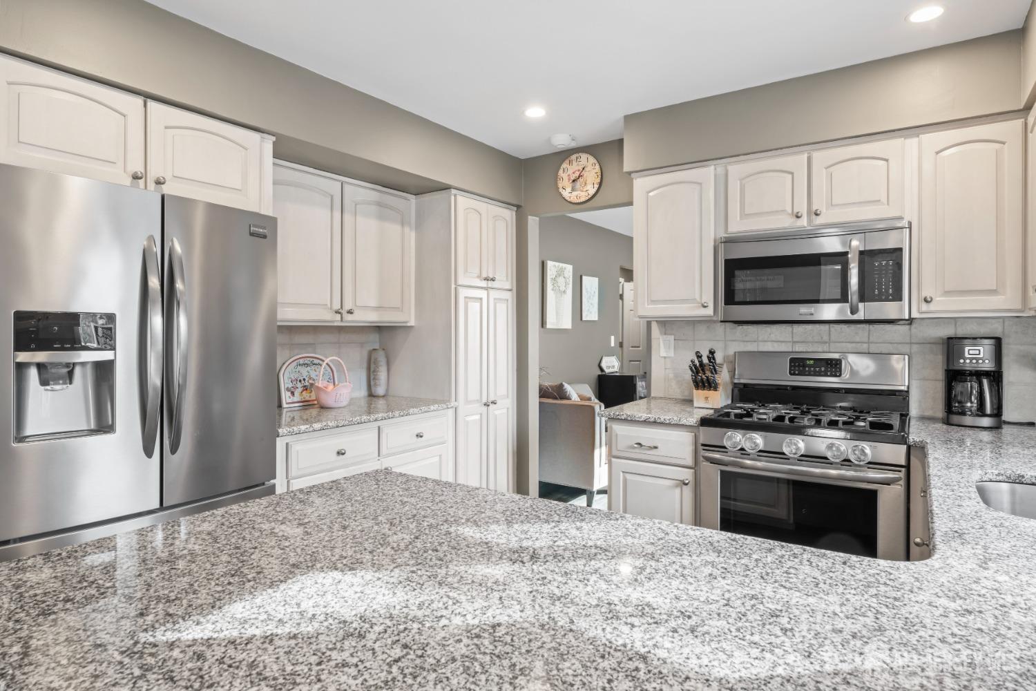 4 Whitman Road Morganville, NJ 07751 - Photo 9 of 45 a kitchen with stainless steel appliances granite countertop a stove a refrigerator and a sink