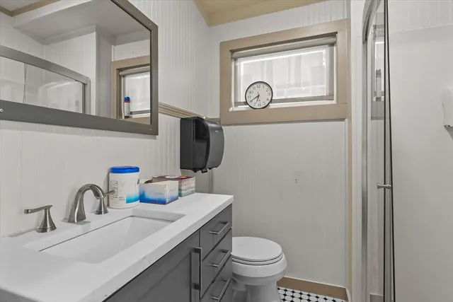 a bathroom with a toilet sink and mirror