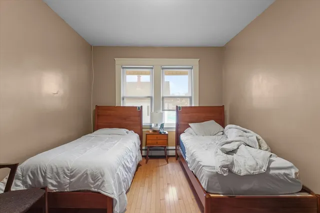 a bedroom with two beds and a window