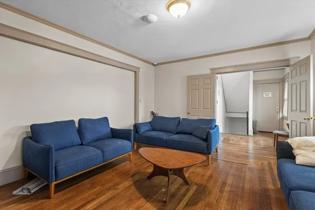 a living room with furniture a couch and wooden floor