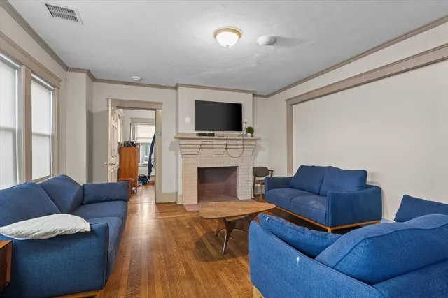a living room with furniture a flat screen tv and a fireplace