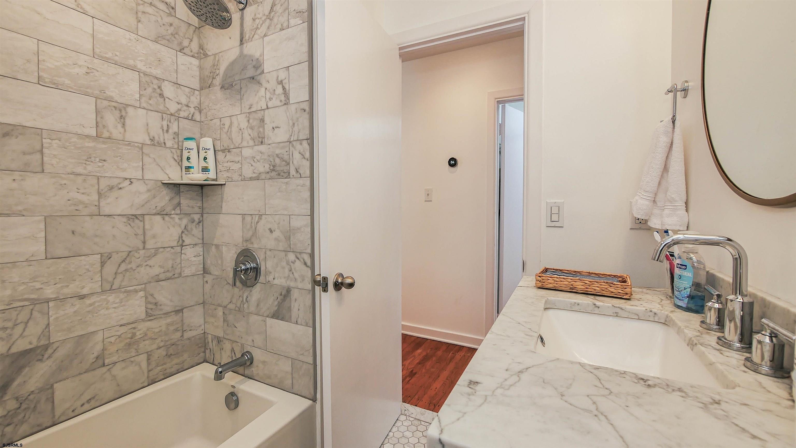 12 North Delavan Avenue, Unit AUGUST 1ST LABOR DAY 2026 Margate City, NJ 08402 - Photo 14 of 41 a bathroom with a tub and shower