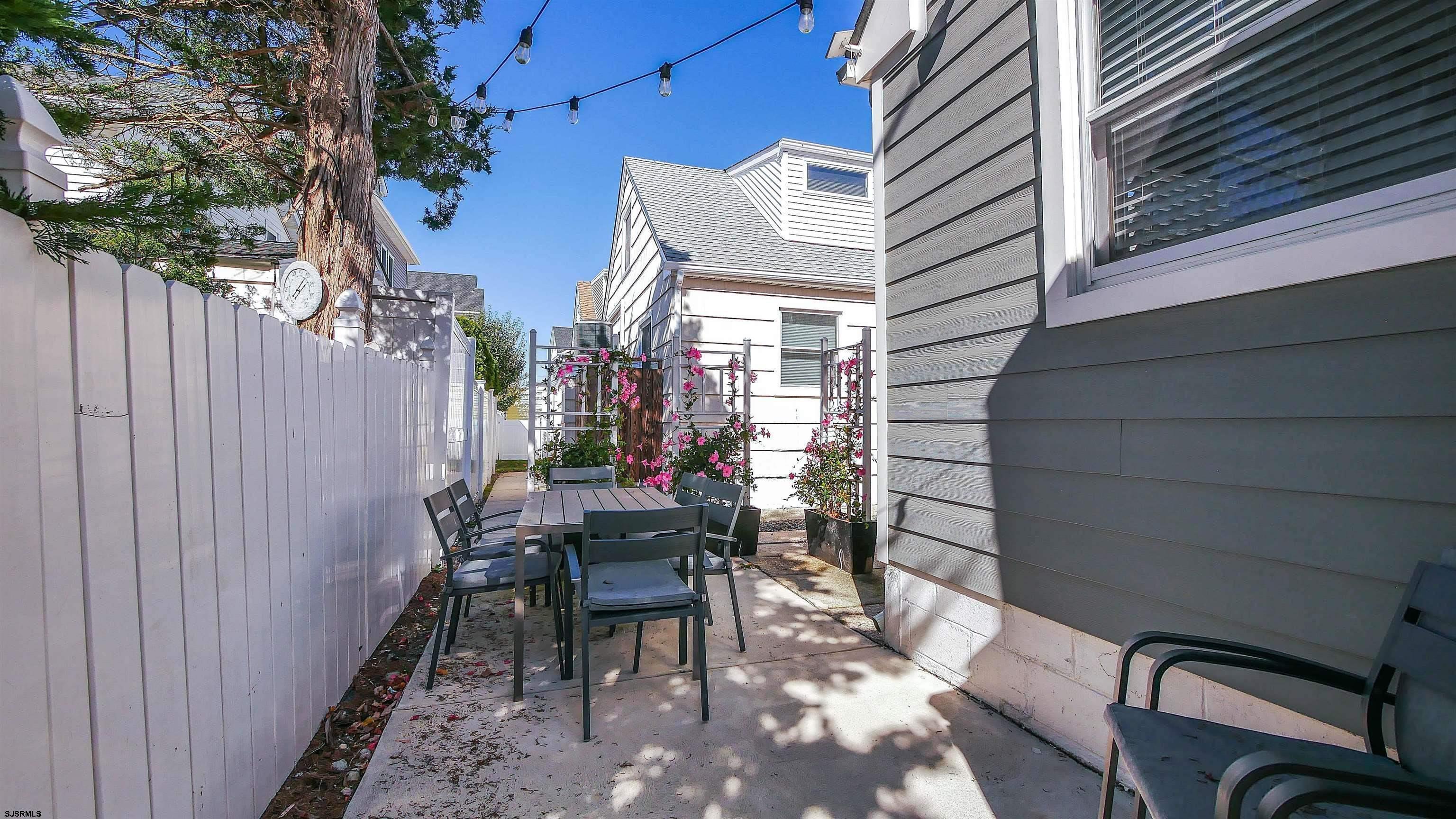 12 North Delavan Avenue, Unit AUGUST 1ST LABOR DAY 2026 Margate City, NJ 08402 - Photo 38 of 41 a view of a patio with table and chairs and potted plants