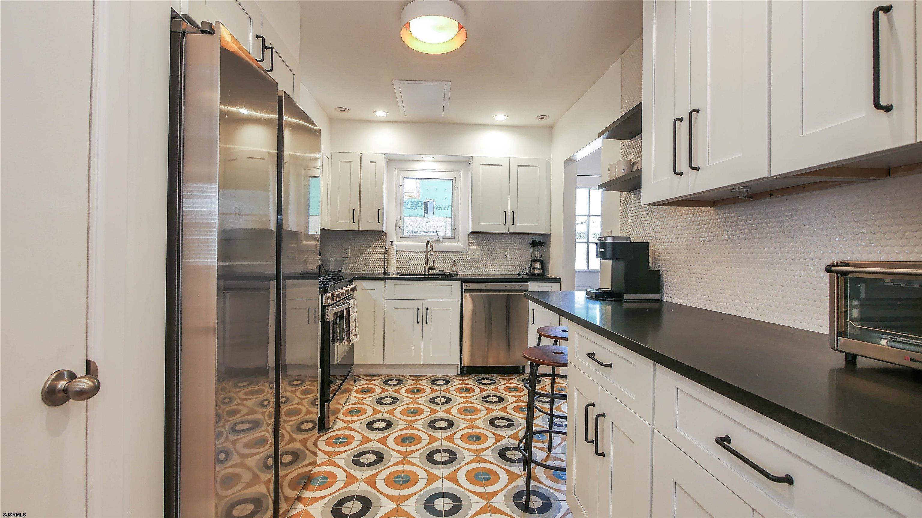 12 North Delavan Avenue, Unit AUGUST 1ST LABOR DAY 2026 Margate City, NJ 08402 - Photo 10 of 41 a kitchen with a sink a refrigerator and cabinets
