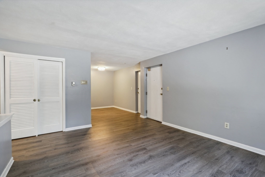 51 Will Drive, Unit 127 Canton, MA 02021 - Photo 4 of 15 a view of an empty room with wooden floor