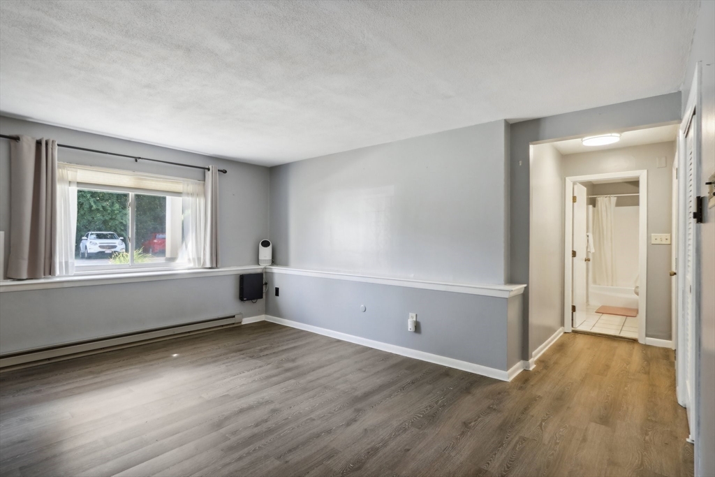 51 Will Drive, Unit 127 Canton, MA 02021 - Photo 5 of 15 an empty room with wooden floor and windows