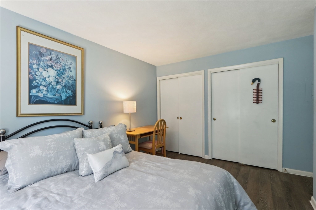 51 Will Drive, Unit 127 Canton, MA 02021 - Photo 10 of 15 a bedroom with a bed and lamp with wooden floor