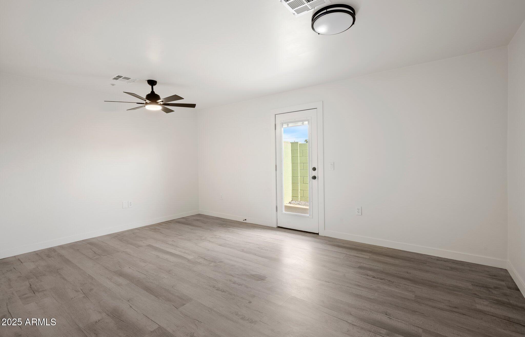 3114 North 68th Street, Unit 2 Scottsdale, AZ 85251 - Photo 18 of 25 an empty room with wooden floor closet and windows
